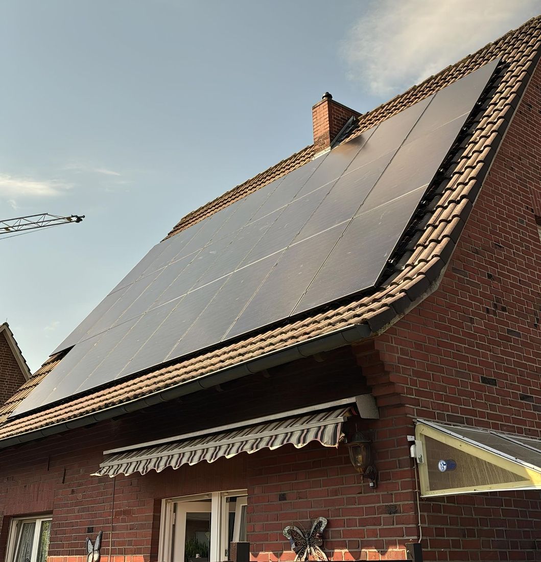 Ein Haus mit Backsteinfassade und einer Solaranlage auf dem Dach